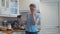 Confused woman in the kitchen with a plunger in her hands