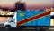 Congo flag on the side of a white van against the backdrop of a blurred city and river. Logistics concept