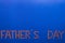 Congratulation on Father`s Day composed of transistors and microcircuits on a blue background. Male holiday, father`s day concept.