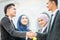 Congratulations! Muslim Asian business people shakes hand.