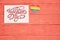 Congratulations on Valentines day, on a white piece of paper and heart with LGBT community flag, lie on a wooden textured