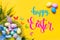 Congratulatory easter background. Easter eggs and flowers. Selective focus. Top view.