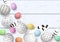 Congratulatory easter on white shabby wooden background. Easter colorful eggs with different simple doodle ornaments and