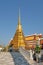 A conical gilded tower on the territory of the Temple of the Emerald Buddha on a sunny day