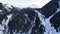 Coniferous forest in snowy mountains. White clouds