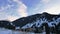 Coniferous forest in snowy mountains. White clouds