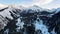 Coniferous forest in snowy mountains. White clouds