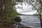 Conifers line the side of Loch Morlich near Aviemore, on a windy wet day in May.