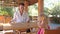 Conjurer Shows Trick with Teaspoon to Little Girl at Table