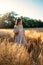 Connect with nature, Slow Down, Be Present, Get Into Your Senses. Peaceful alone Young woman in dress walking on wheat