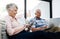 Connected living in retirement. a senior woman using digital tablet while her husband uses a laptop at home.