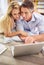 Connected in more ways than one. a mature couple lying on their living room floor doing some online research.