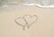 Connecting hearts in beach sand