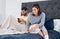 Connecting in quarantine. a young couple using their wireless devices in bed.