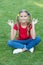 Connecting to your higher self. Happy child keep hands in mudra. Little girl meditate on green grass. Mudra of