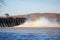 The Conowingo dam releases water and the steam relects a rainbow