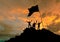 Conquest of height, silhouettes of three people, on top of a mountain, with a flag.