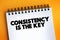 Consistency Is The Key text quote on notepad, concept background