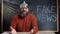 conspiracy theory video blog. Caucasian bearded man sitting at a table against the background of a chalkboard with the