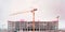 Construction of apartment building cranes above unfinished multistorey panel building , Generative AI