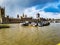 Construction around big ben tower at westminster abbey in london with vessels river thames water walk blue sky clouds