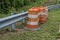 Construction barrels alongside a guardrail