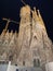 Construction of Basilica the Sagrada Família at night with black sky background.