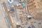 Construction building site materials pipes machinery equipment view from above gravel sand soil drone