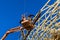 Construction carpenter roofer worker nailing wood beams with hammer on roof installation