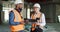 Construction, clipboard and walkie talkie, communication and working, black man and mature woman talk, inspection and