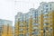 Construction complex with high rise yellow residental apartment buildings with many windows and balconies in city