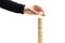 Construction concept on white background. man`s hand builds a tower of toy wooden round blocks