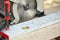 A construction contractor worker using a worm-driven hand-held circular saw to cut boards and plastic. Construction