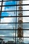 Construction crane behind a window front against blue sky with c