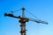 Construction crane on the blue sky background