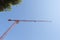 Construction crane with blue sky on background and homes