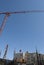 Construction crane with blue sky on background and homes