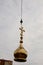 Construction crane with boom structure at construction site. The ascent of the golden cross to the dome of the temple, gray