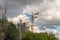 Construction crane and building under construction against sky in clouds. Industrial Crane operating and lifting an concrete block