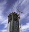 A construction crane builds a tall downtown apartment building