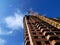 Construction crane near building on blue sky background.