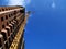 Construction crane near building on blue sky background.