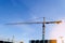 Construction crane tower on blue sky background. Crane and building working progress. Worker. Empty Space for text. Construction c