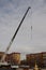 Construction cranes with boom structure at construction site. Preparation for the ascent of the cross to the dome, gray cloudy