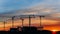 Construction cranes working at sunset, workers engaged in construction, time lapse