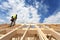 Construction crew working on the roof against blue sky.