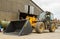 Construction digger loader in farm yard with barn