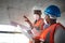 Construction that doesnt compromise on quality. a young man and woman going over building plans at a construction site.