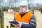 Construction employee with documentation near building