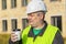 Construction Engineer with cup of coffee near building